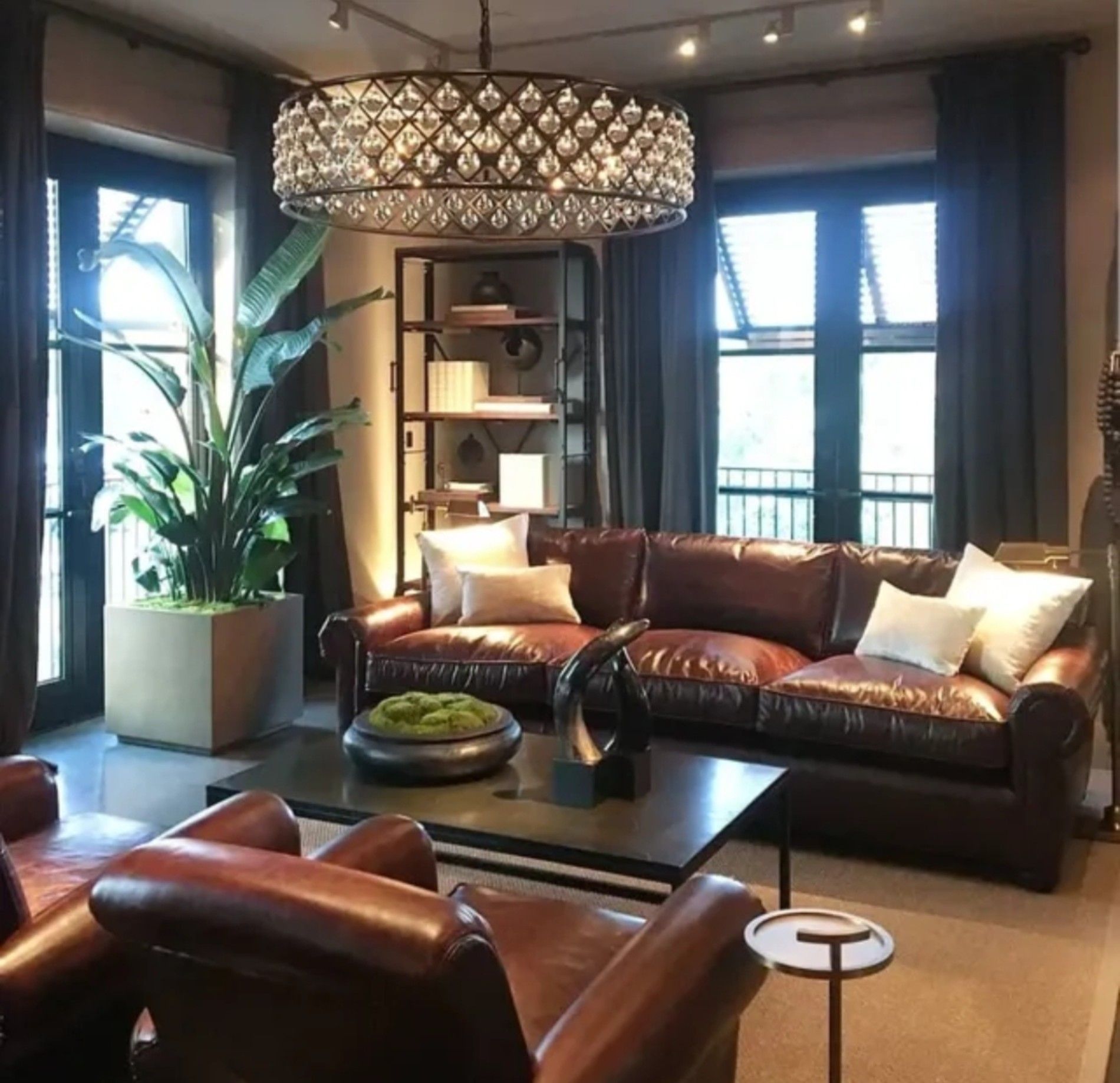 a living room with a brown leather couch and chairs