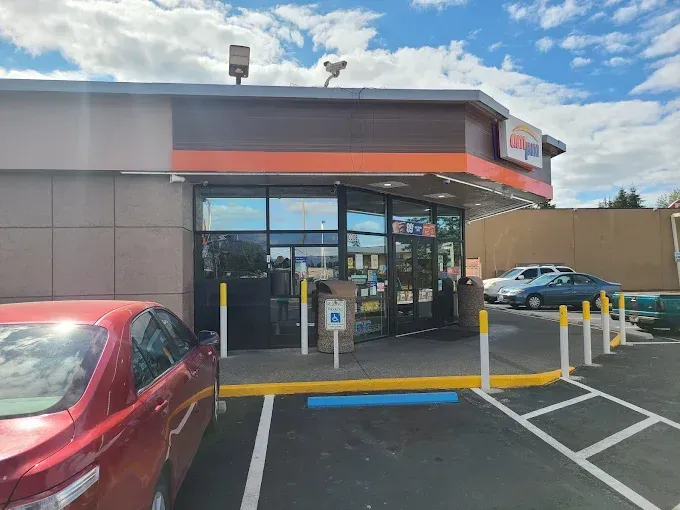 Exterior of a Walgreens with glass doors and a red car parked in front.