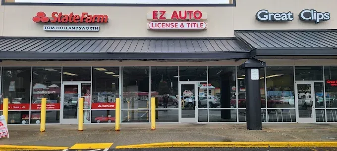 Exterior of a strip mall with a State Farm, EZ Auto License & Title, and Great Clips.