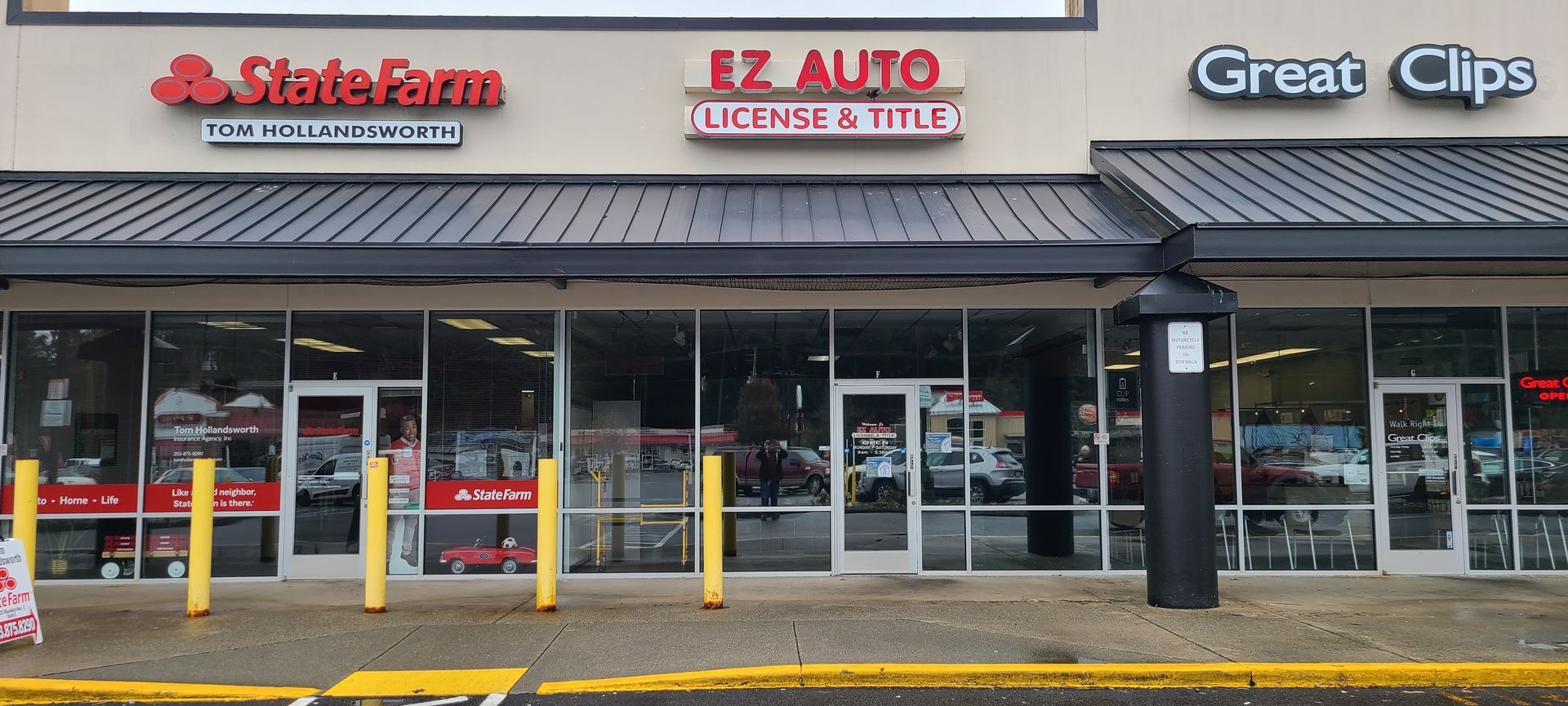 A strip mall with State Farm, EZ Auto, and Great Clips storefronts.