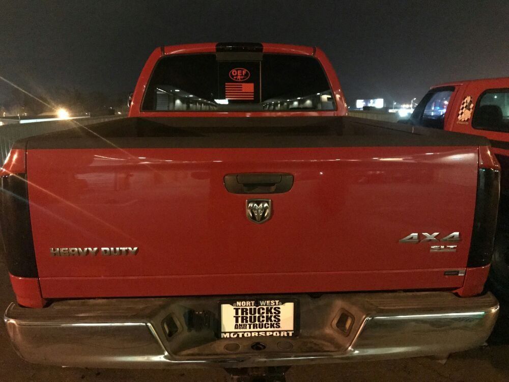 Red Dodge Ram truck, rear view, at night.