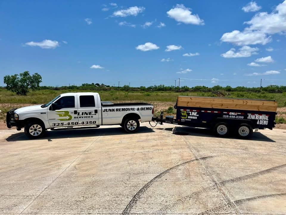White pickup truck with a black trailer parked on a concrete lot under a blue sky