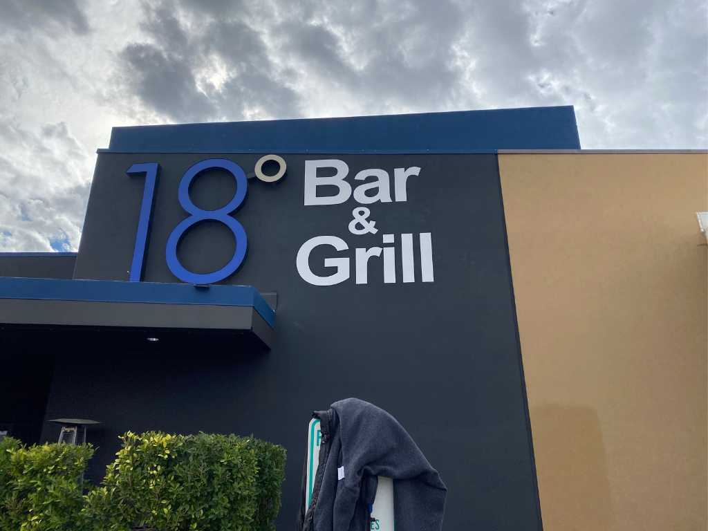 A building with a sign that says bar and grill on it.