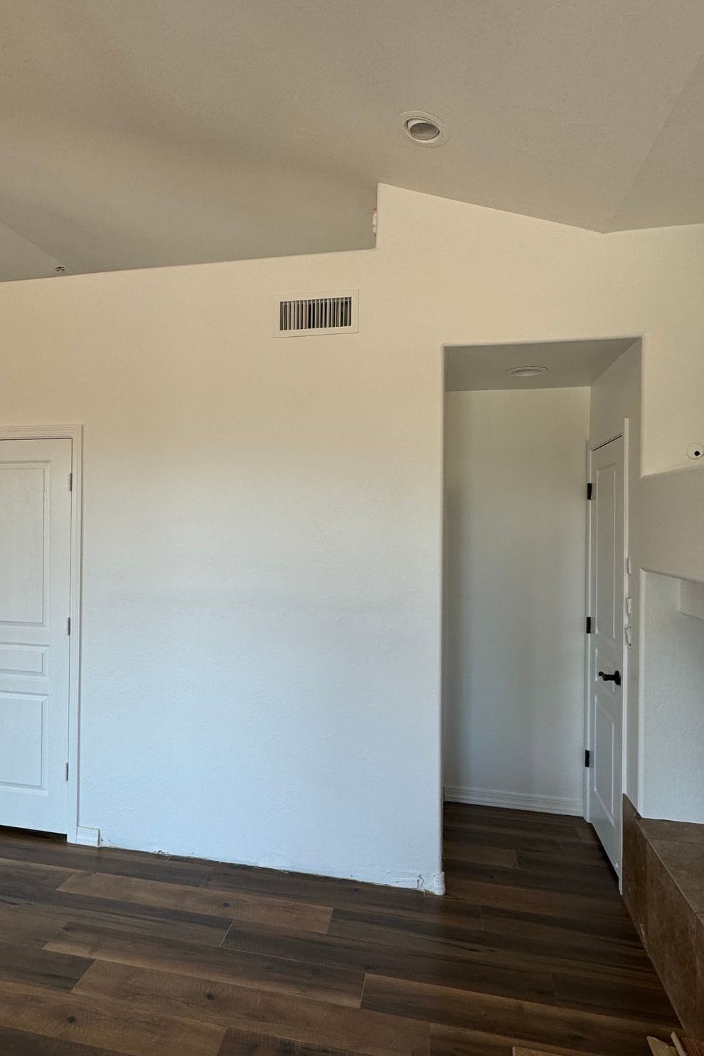 A living room with hardwood floors and white walls.
