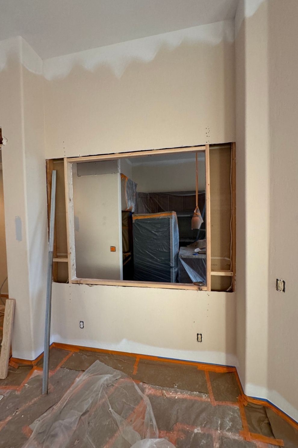 A room that is being remodeled with a window in the wall.