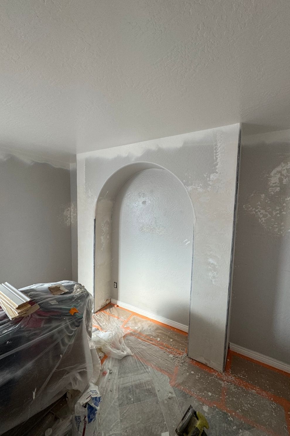 A living room with a fireplace in the middle of it is being painted.