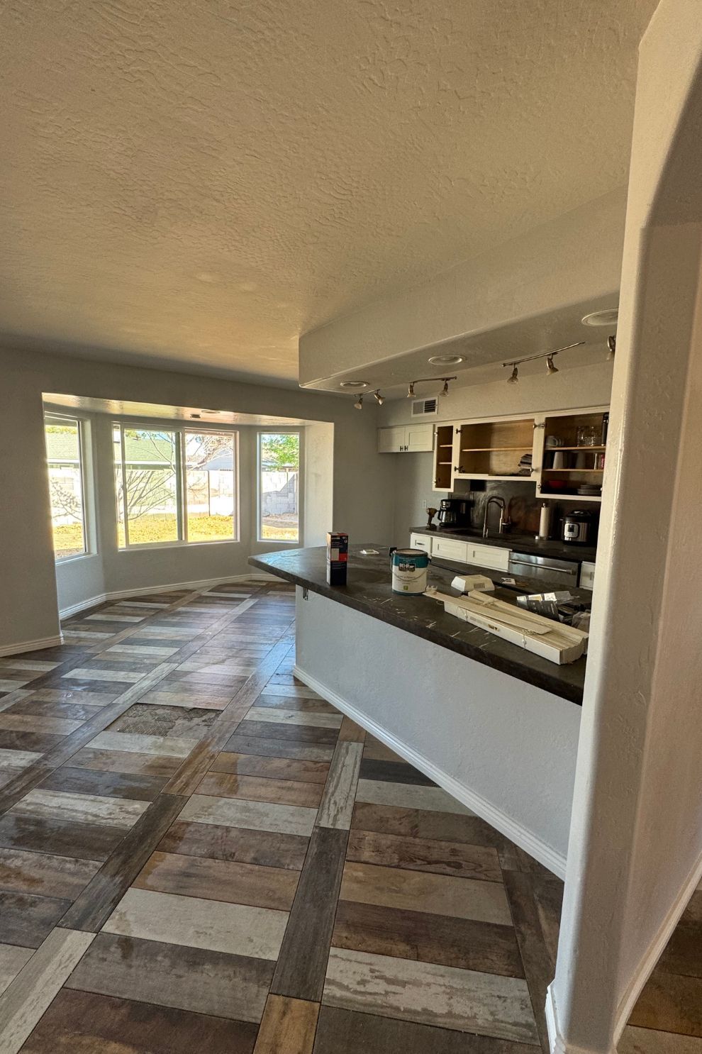 A kitchen with a large island and a wooden floor.