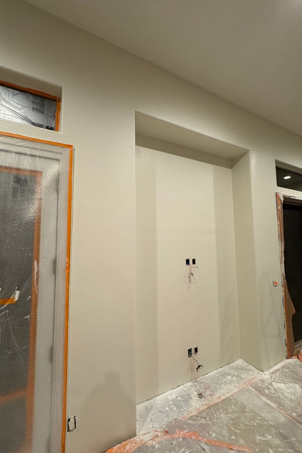 A room with a door and a window is being painted.