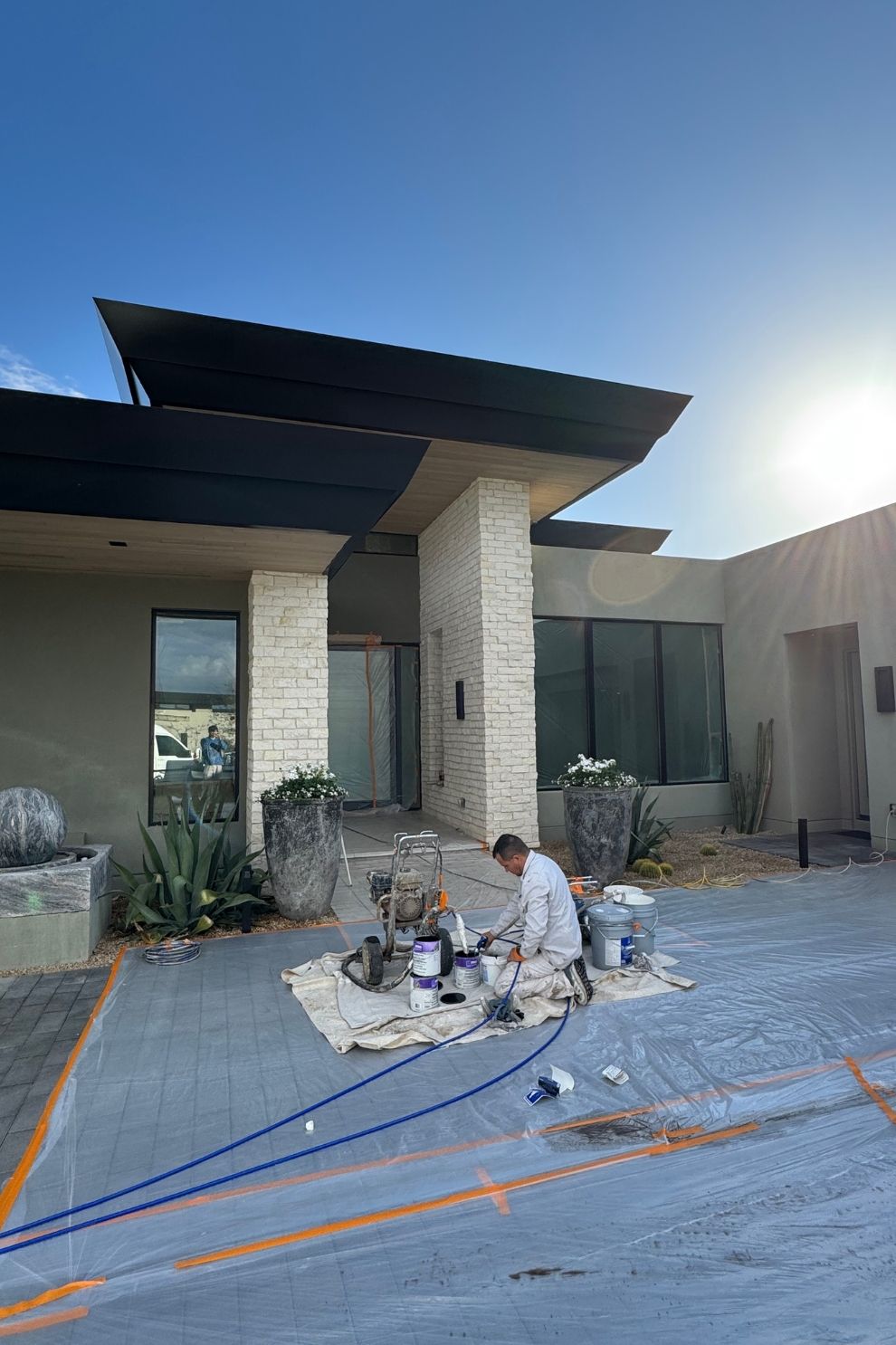 A man is painting the front of a house.