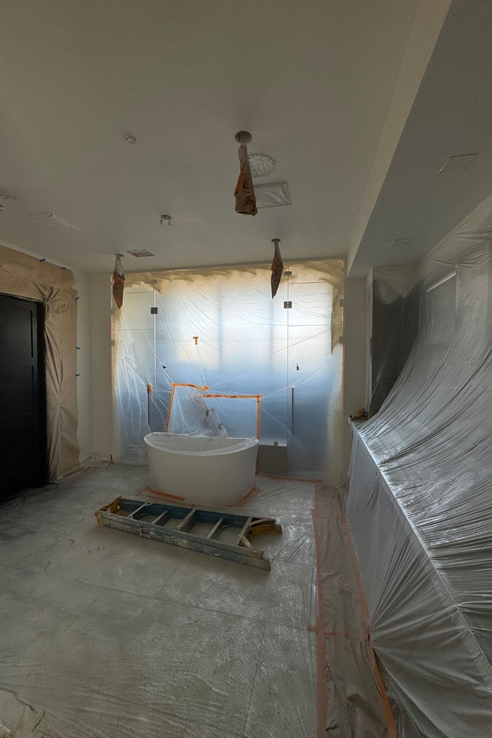 A bathroom under construction with a bathtub and a ladder.