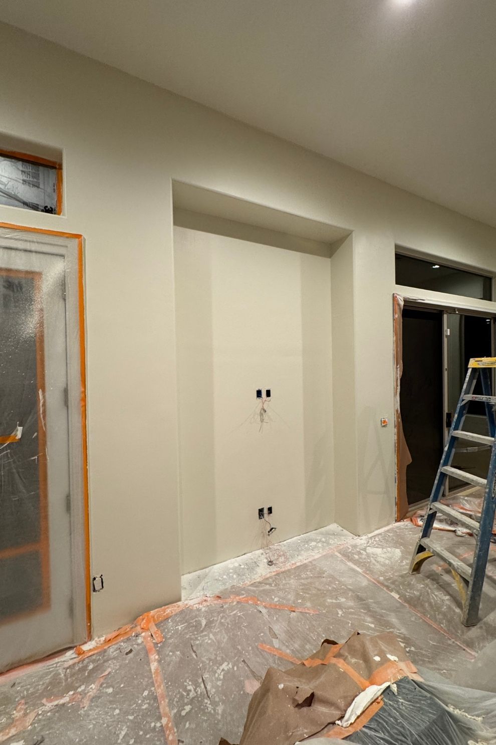 A room that is being painted with a ladder in it.
