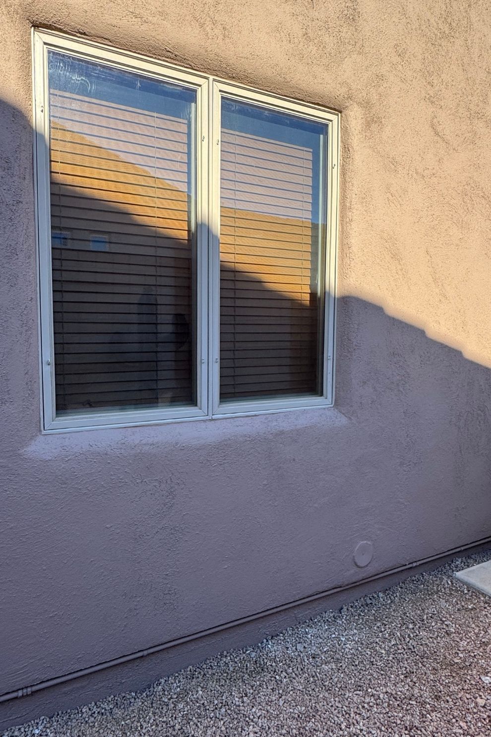A window on the side of a building with blinds on it.