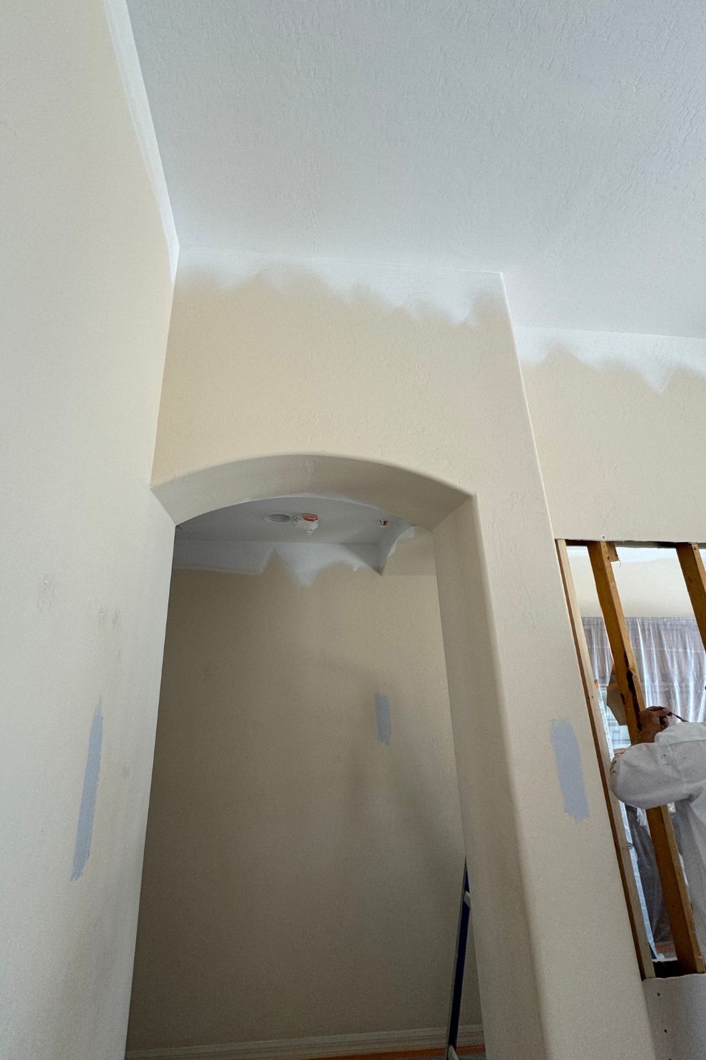 A room with white walls and a staircase in the background
