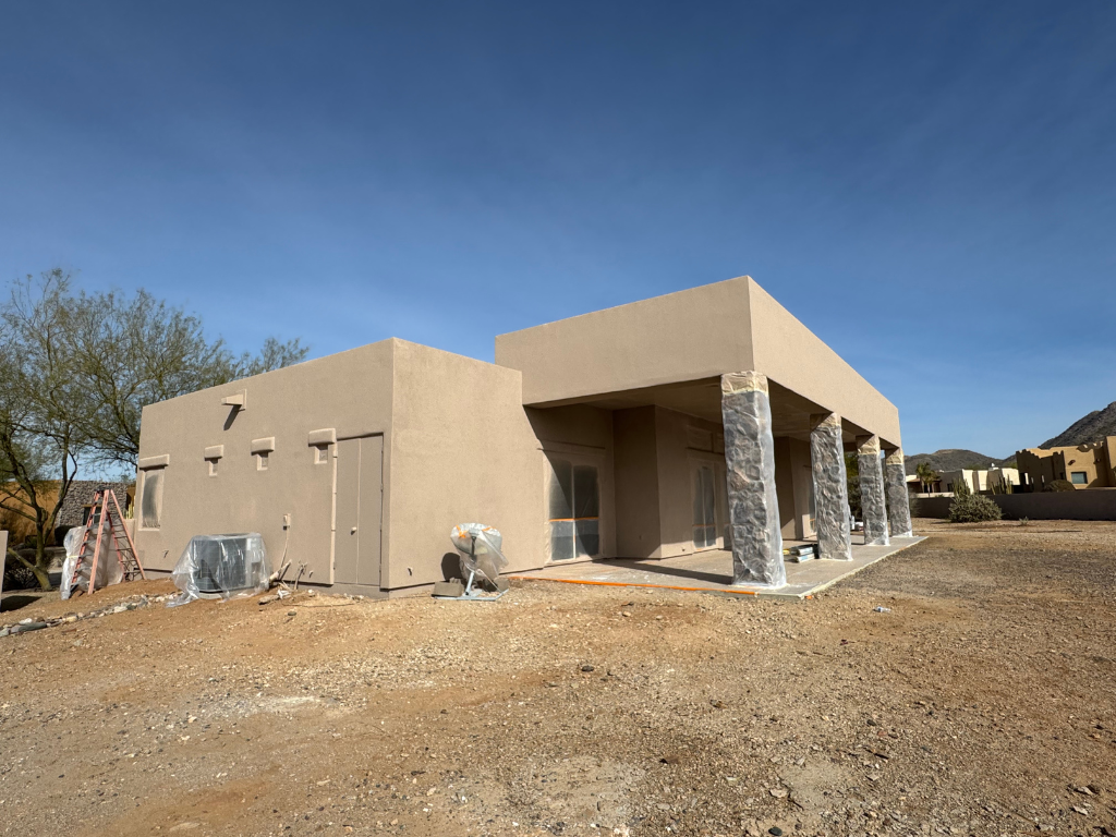 A house is being built in the desert with a lot of dirt in front of it.