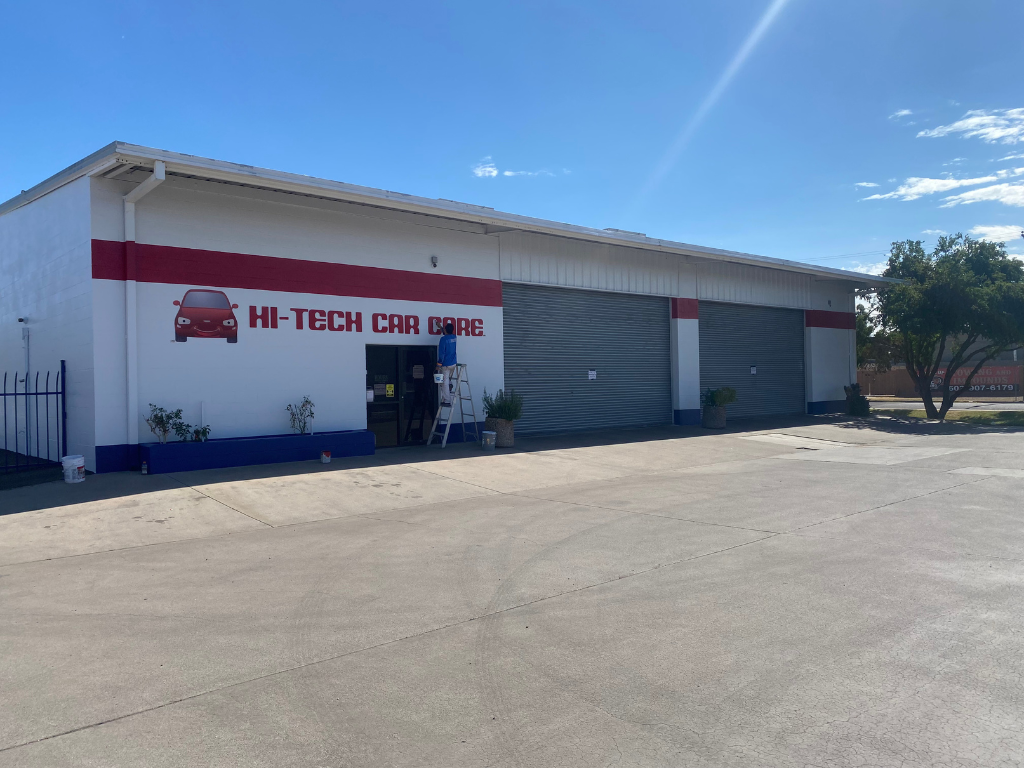 A white and red building with a sign that says hi-tech car care