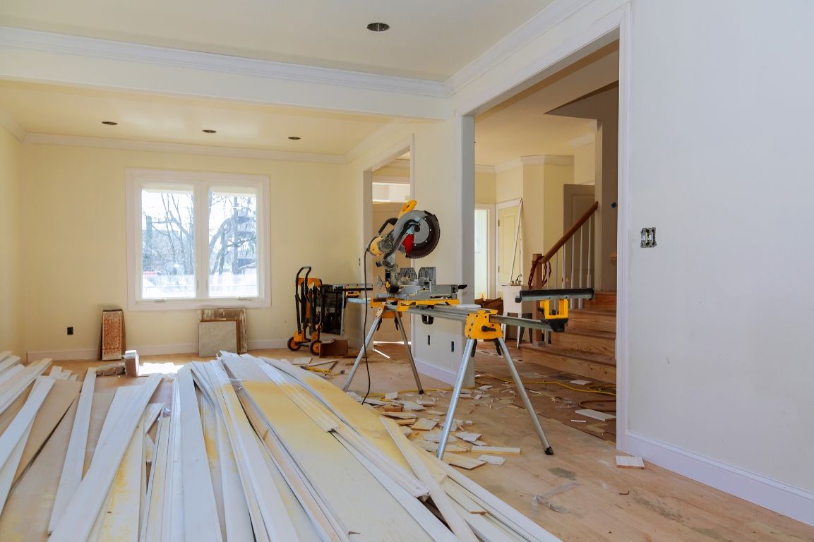 A house is being remodeled and a saw is sitting on a table in the middle of the room.