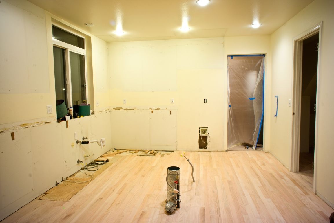 An empty room with a wooden floor and a window.