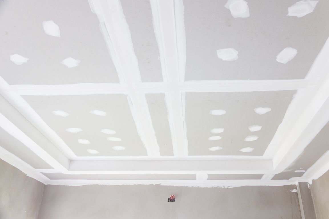 A room with a ceiling that is being painted white.