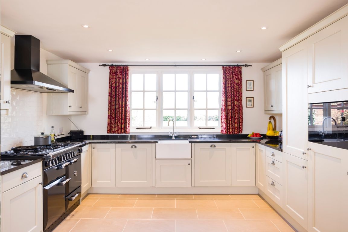 A kitchen with white cabinets and black appliances