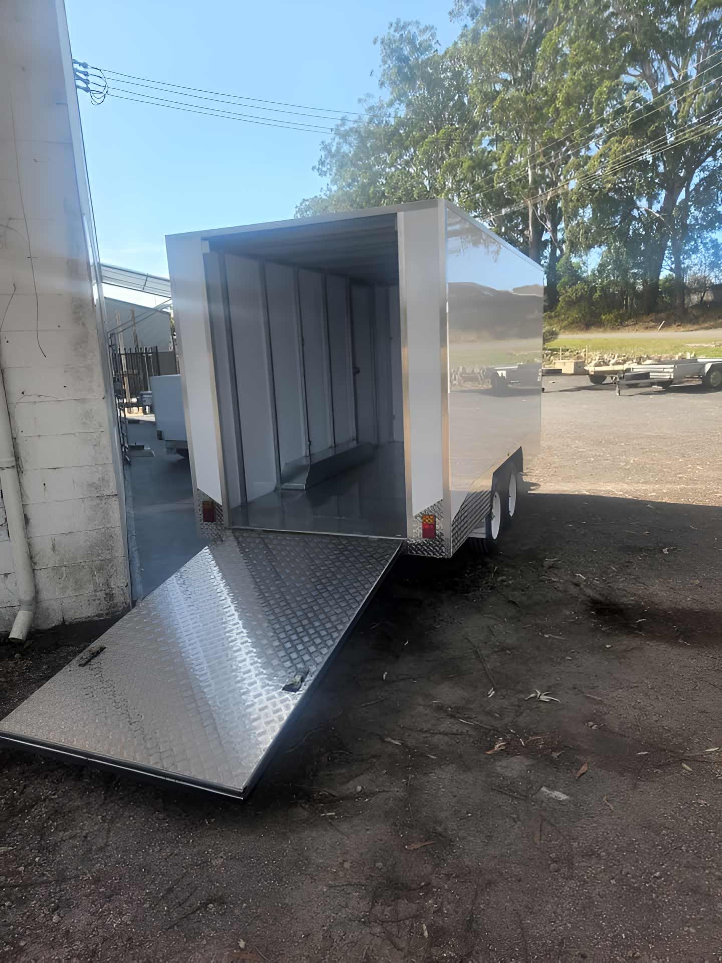 A trailer with the door open is parked in a parking lot Hastings Trailer Centre in Port Macquarie, NSW