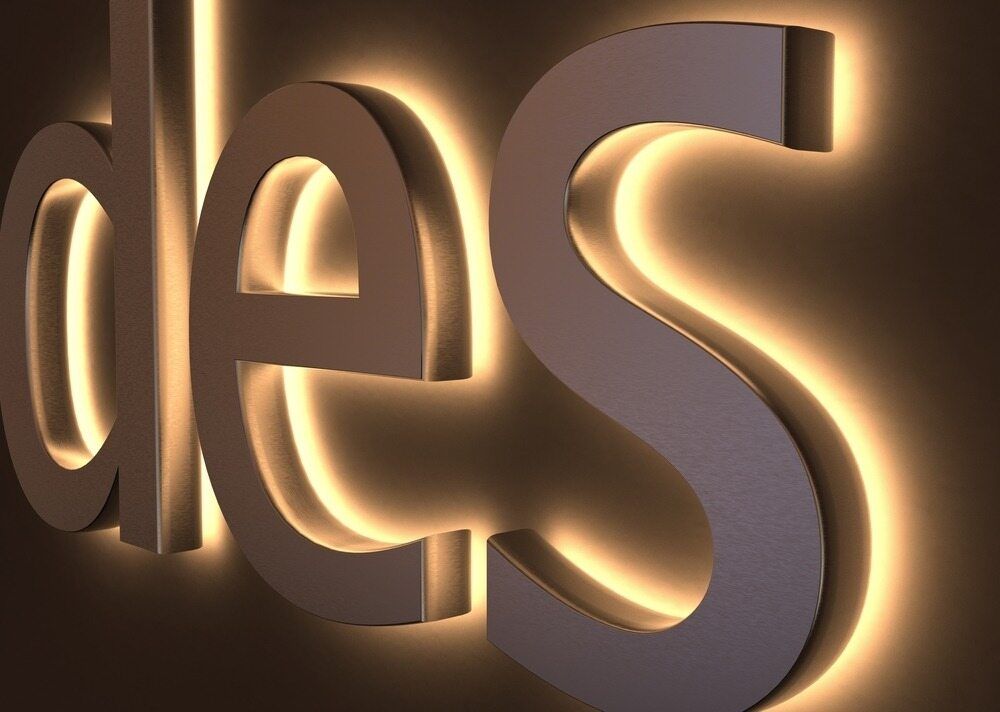 The Word Des is Lit Up on a Brown Background — Caledonian Colour In Kunda Park, QLD