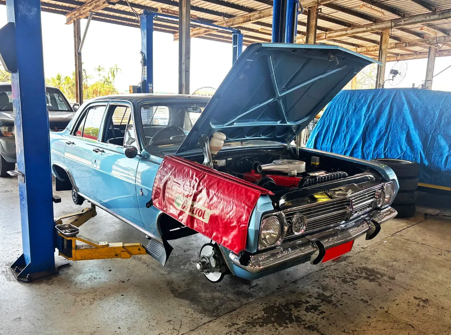 Blue Classic Car on a Lift in a Garage With Hood Open — Jims Auto Care in Berrimah, NT