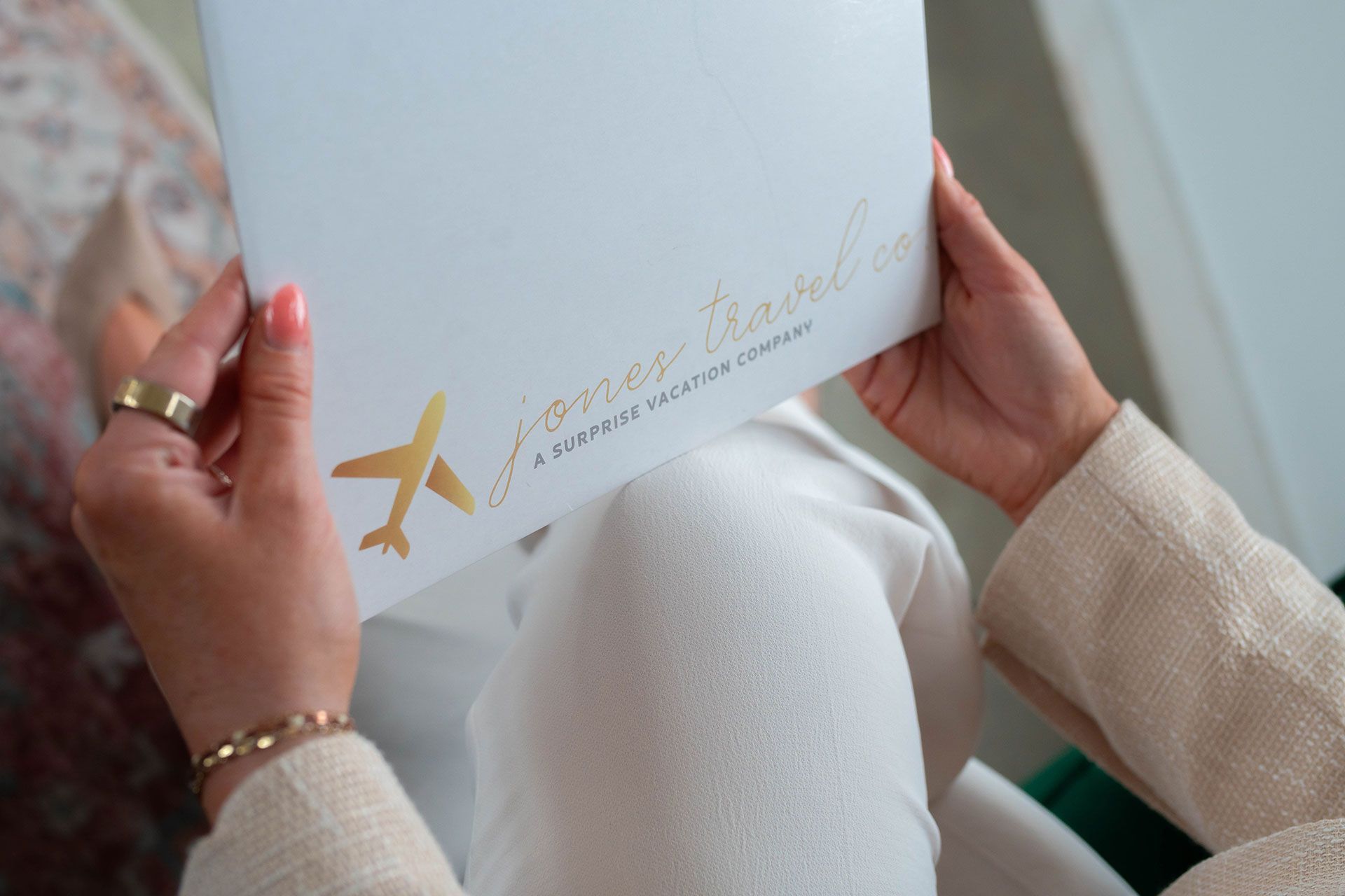 A woman is holding a white box with an airplane on it.