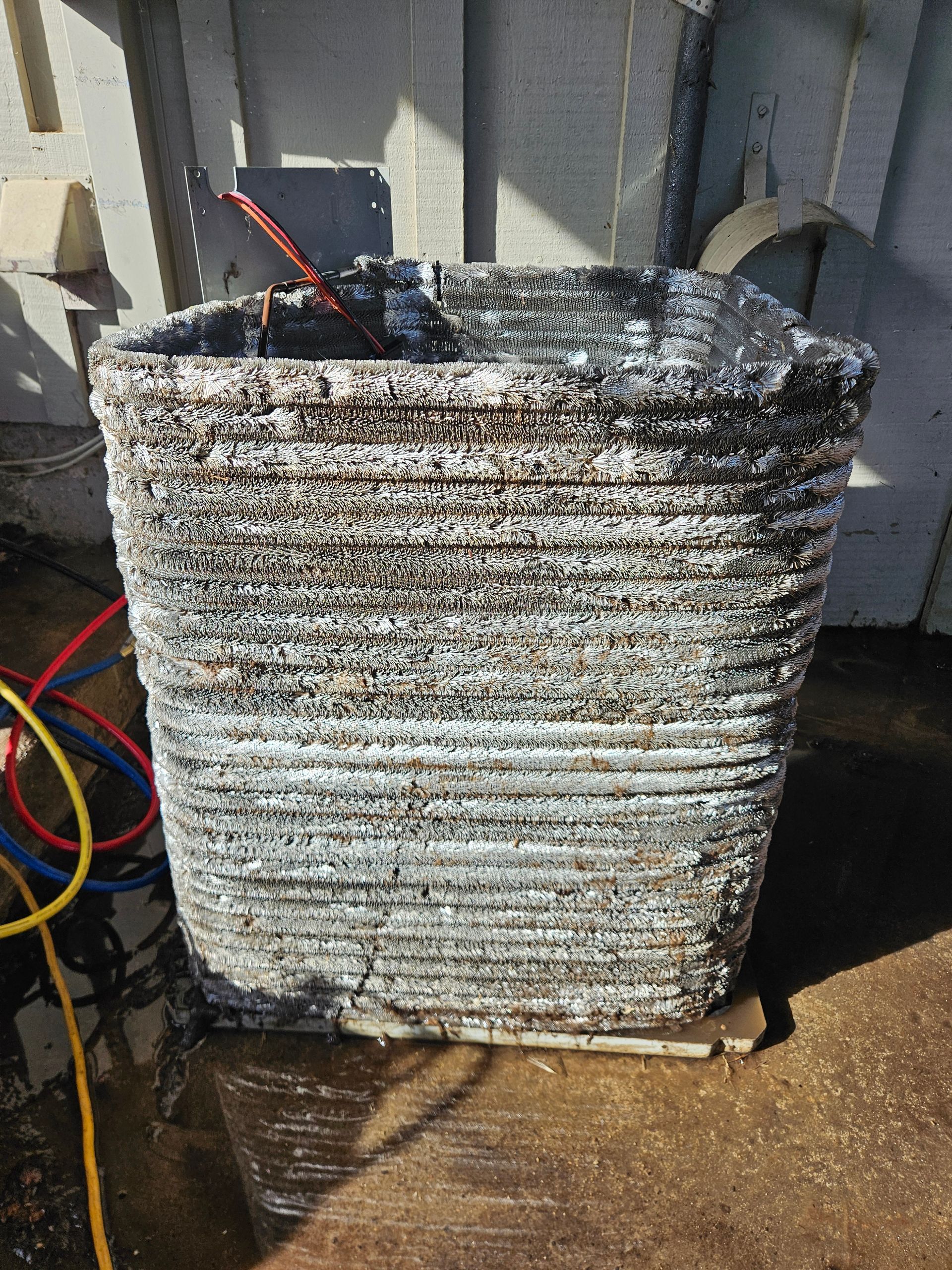 Stacked metal block outdoors, resembling a weathered, layered container.