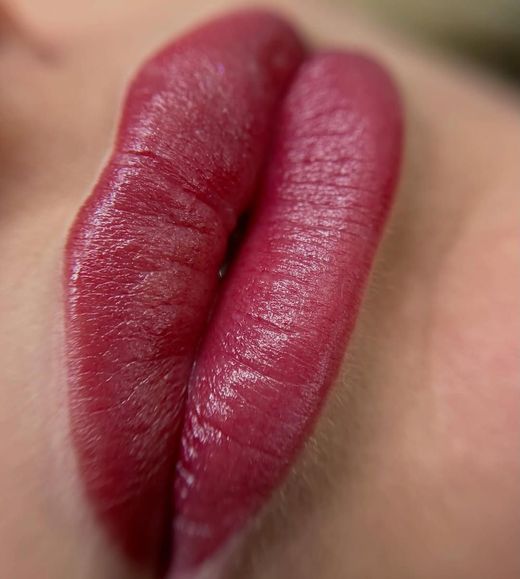 Primo piano di labbra rosse lucide con rossetto rosso scuro