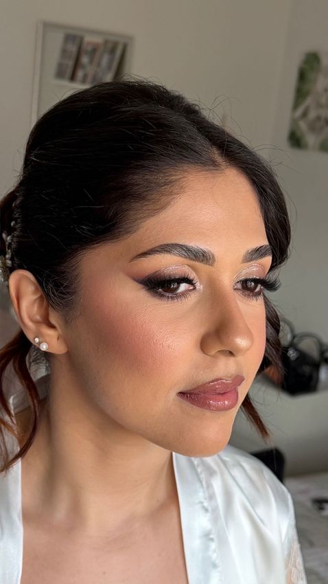 Ritratto ravvicinato di una donna con un trucco occhi intenso e un rossetto color magenta acceso.