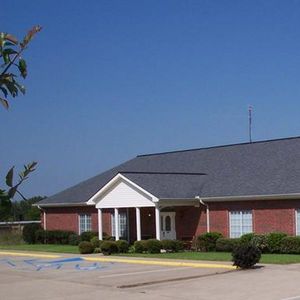 a brick house with a gray roof and a white porch
