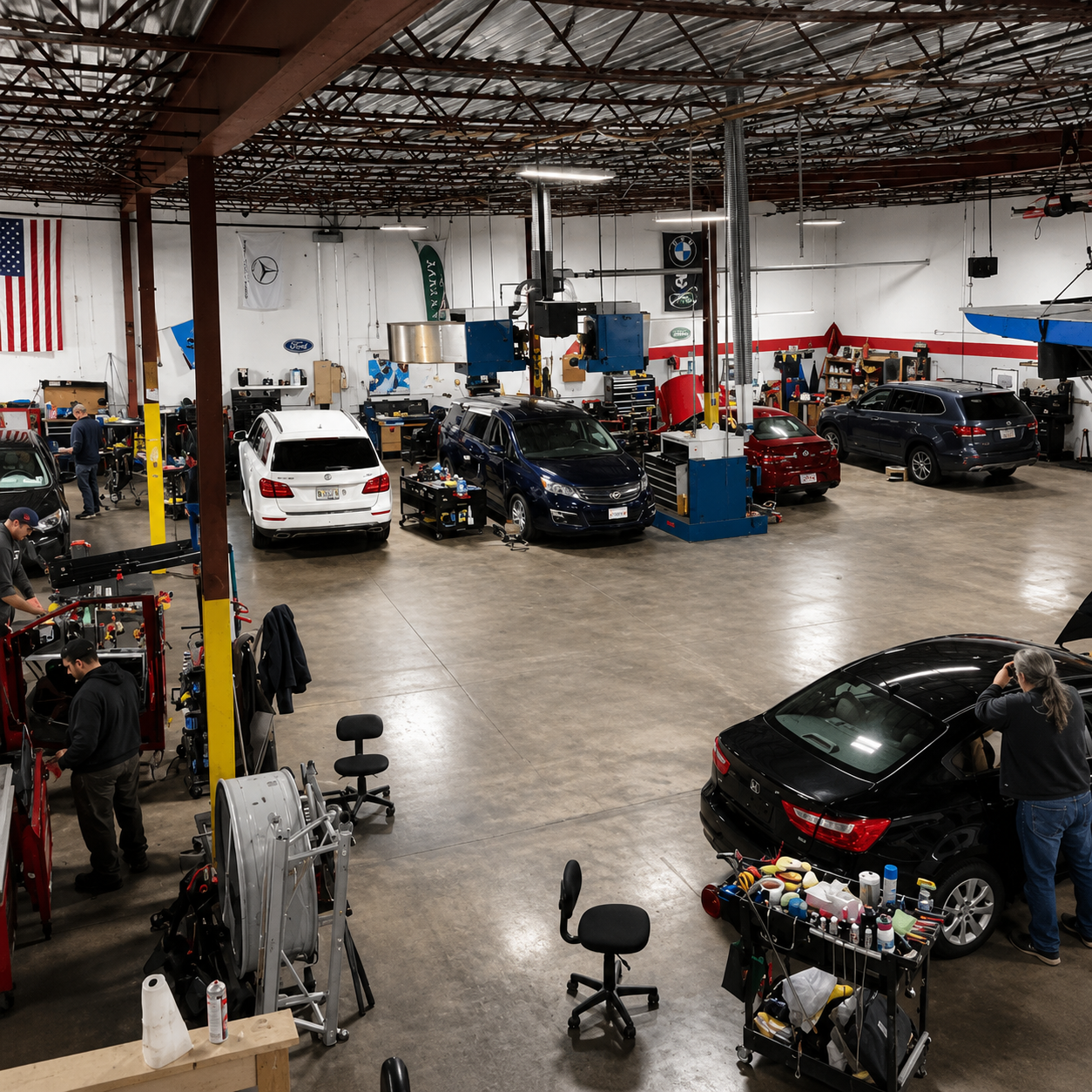 Person inspecting the engine of a silver car in a garage with the hood open