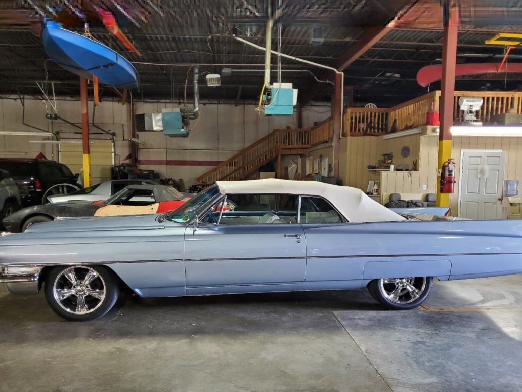Blue classic convertible car in a garage, side view