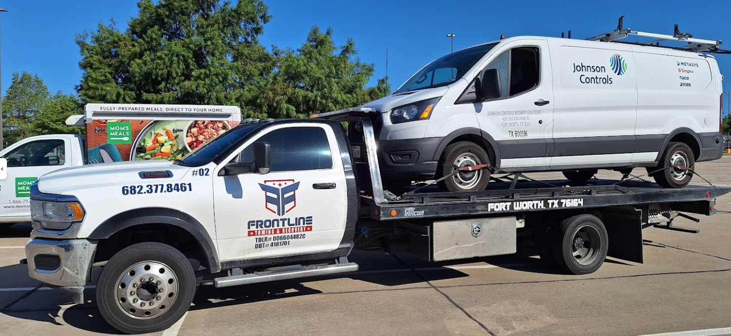 Two tow trucks are parked next to each other in a parking lot.
