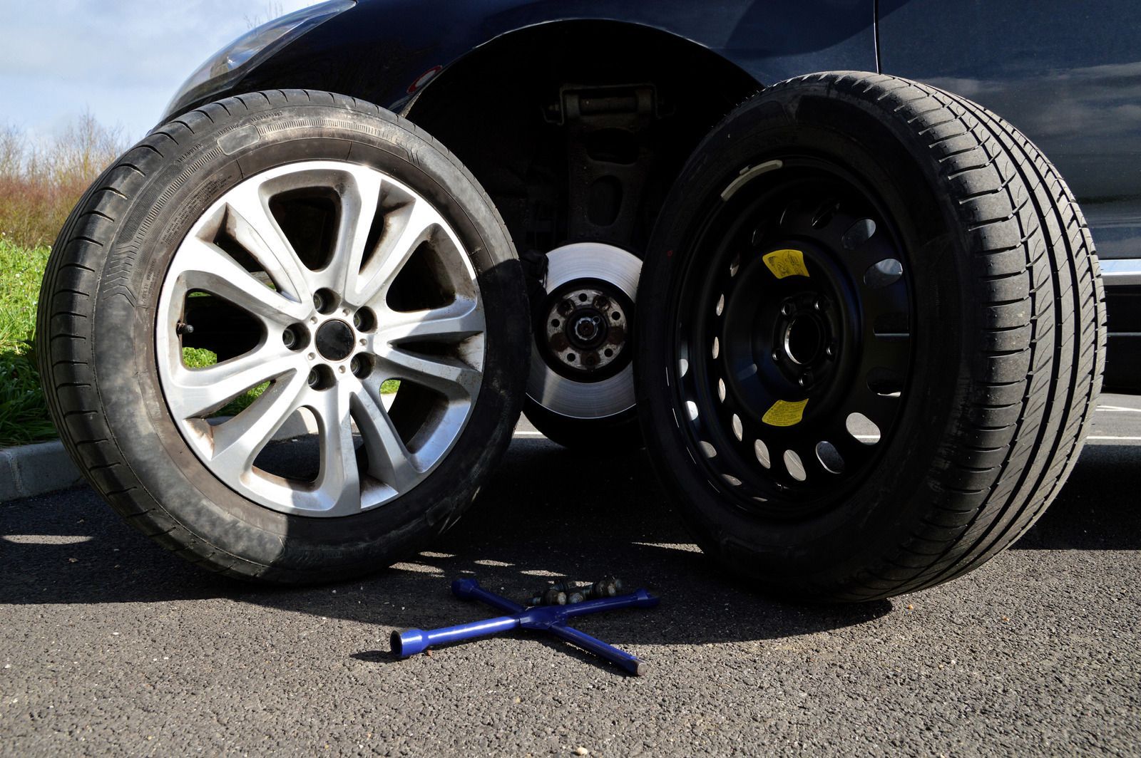 Two tires are sitting next to each other on the side of a car.