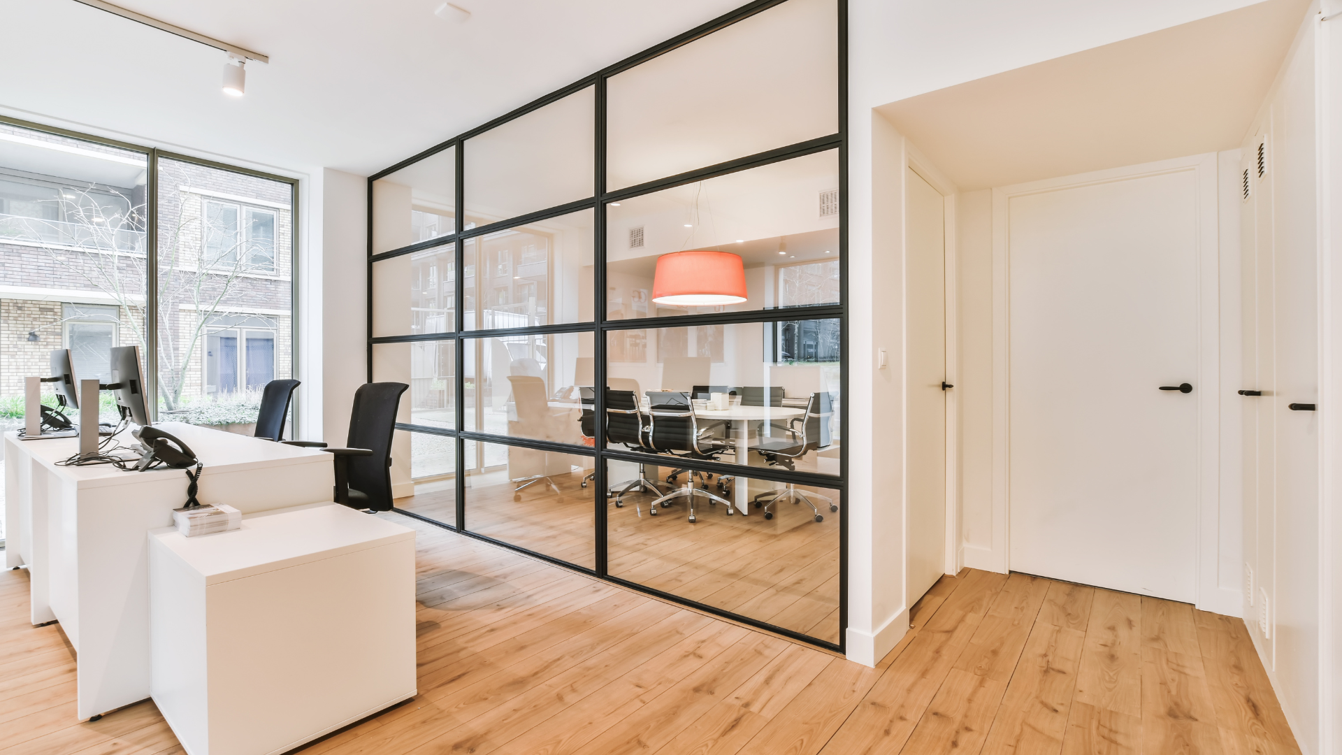 a modern office with a glass wall and wooden floors in woburn ma cleaned by thinkfast cleaning.