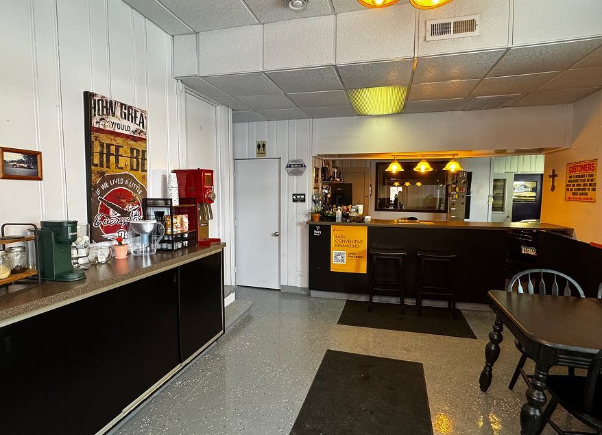 Restaurant interior with buffet counter, tables, chairs, and warm overhead lighting | Exodus Motor Works LLC