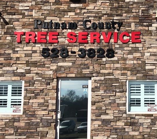 Putnam County Tree Service storefront with red letters, a phone number, and a stone facade.