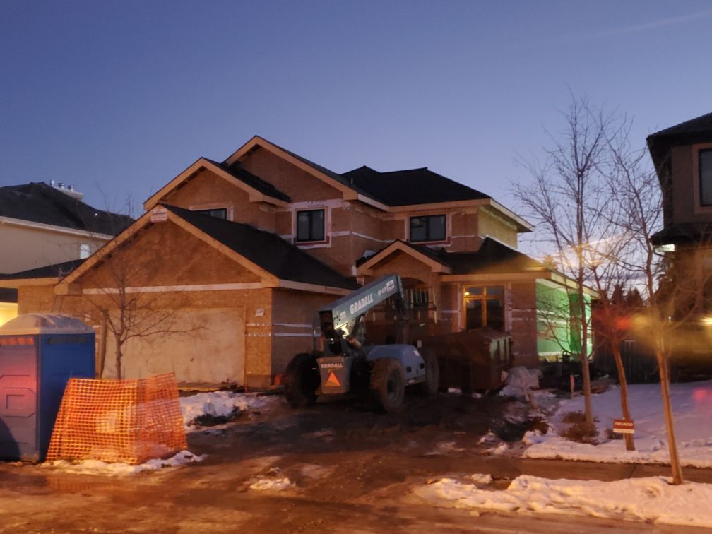 A large house under construction with a tractor in front of it