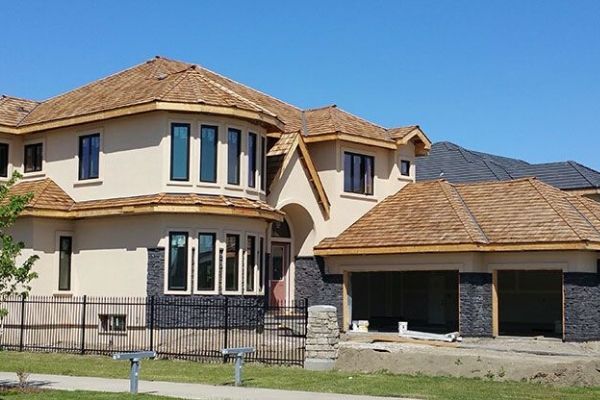 A large house with a wooden roof is under construction