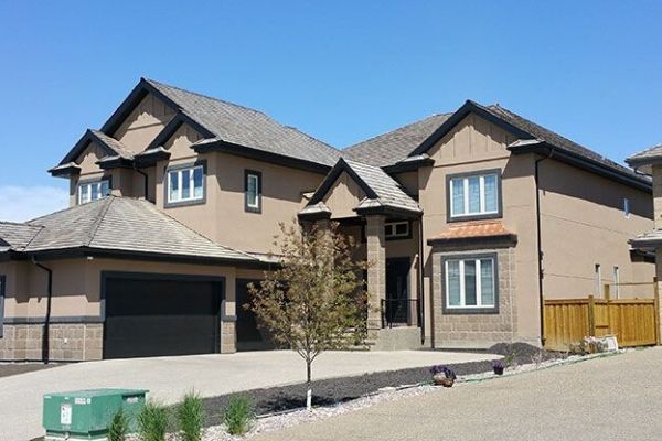 A large brown house with a black garage door