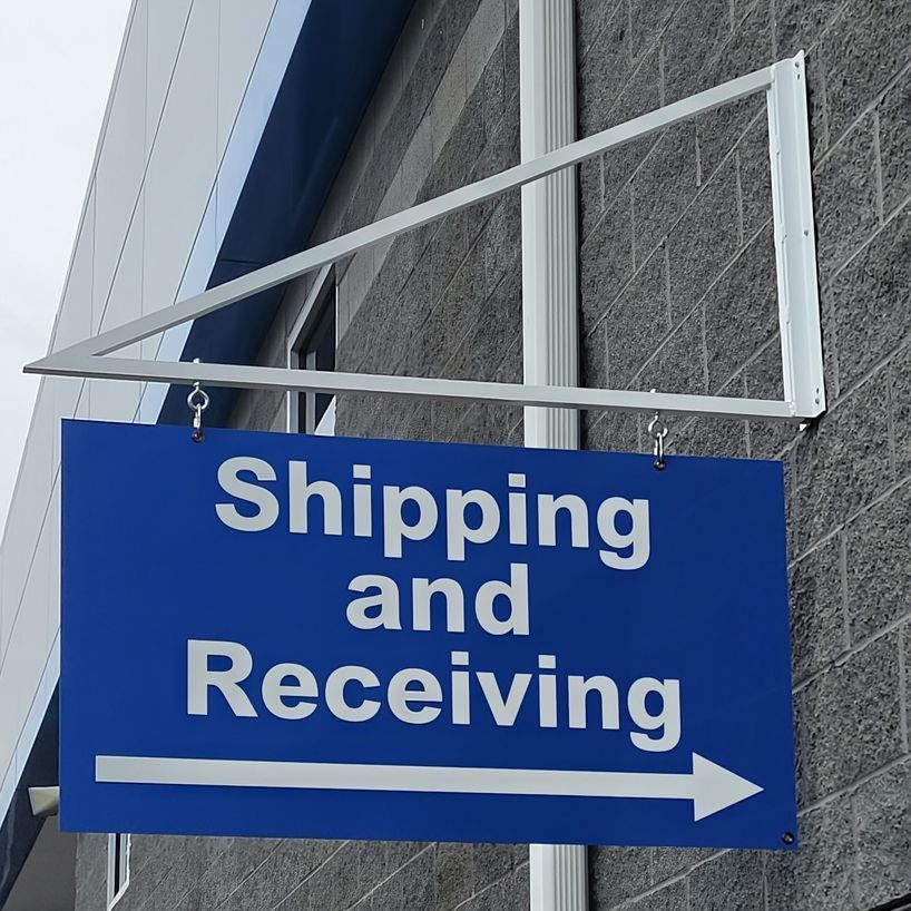 Shipping and receiving signage attached to wall by A frame bracket