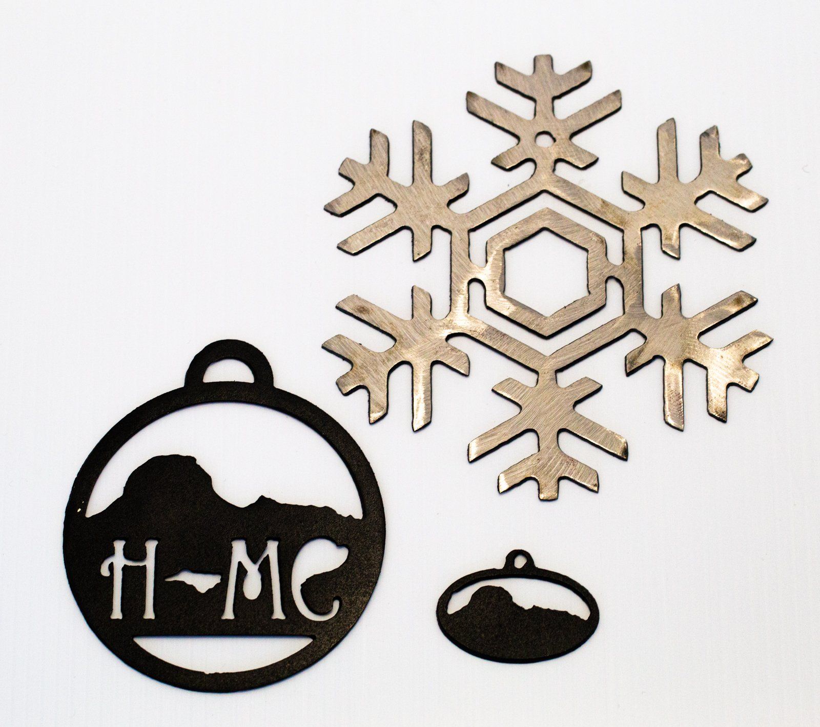 Ornaments cut with a laser into the shape of Pilot Mountain and a snowflake