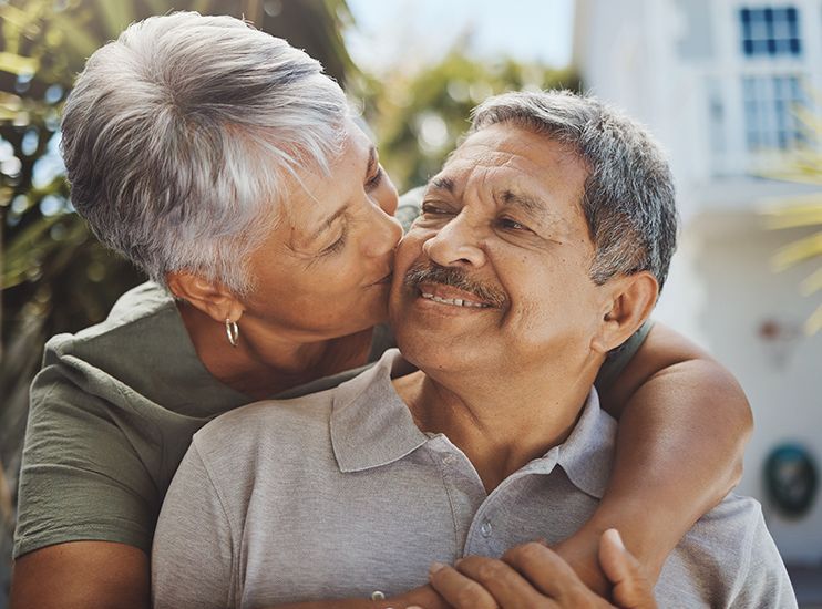 a woman is kissing a man on the cheek .