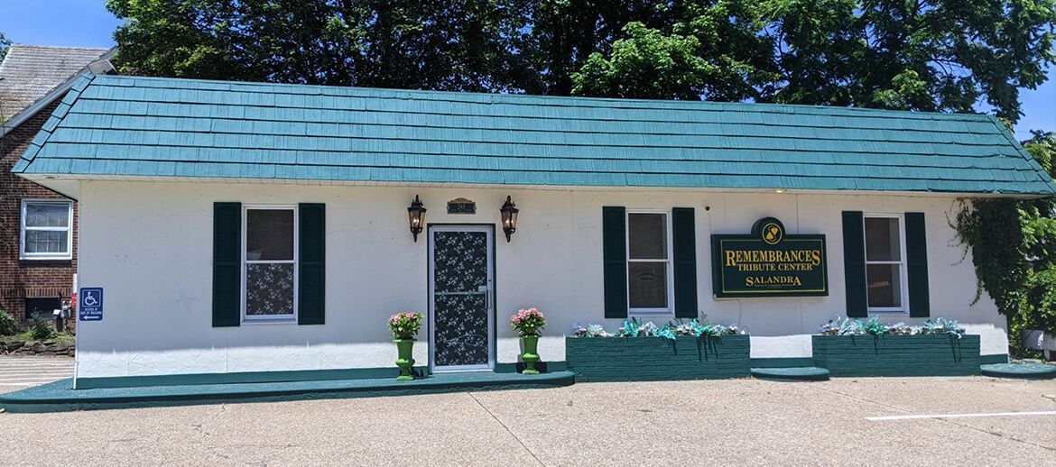 a white house with a green roof and black shutters
