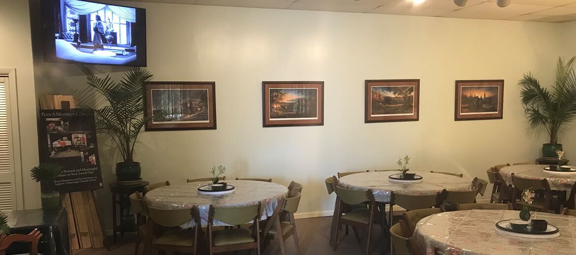 a dining room with tables and chairs and a television on the wall .