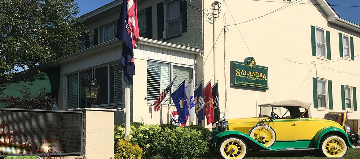 a yellow and green car is parked in front of a house .