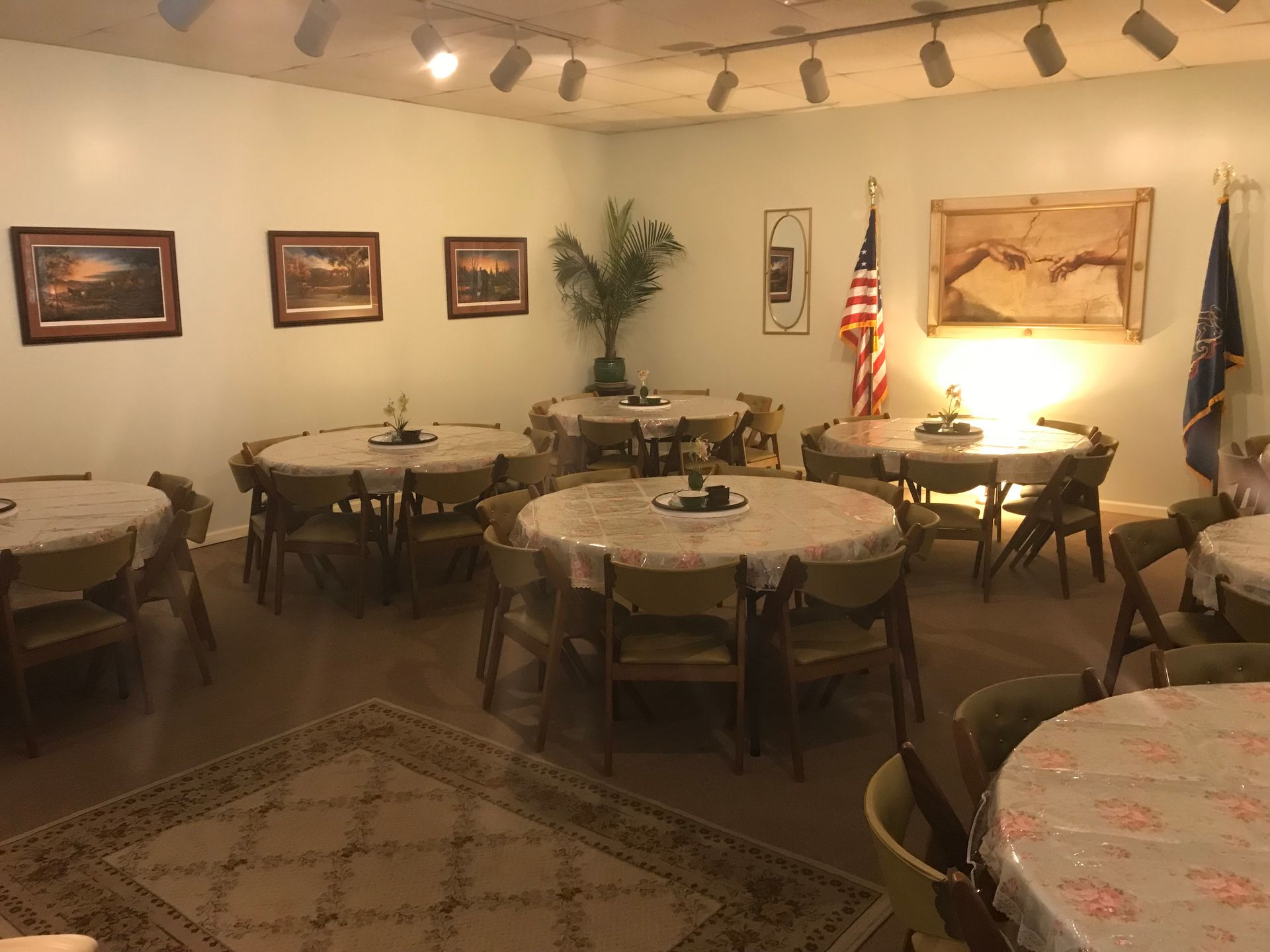 A room with tables and chairs and a flag on the wall