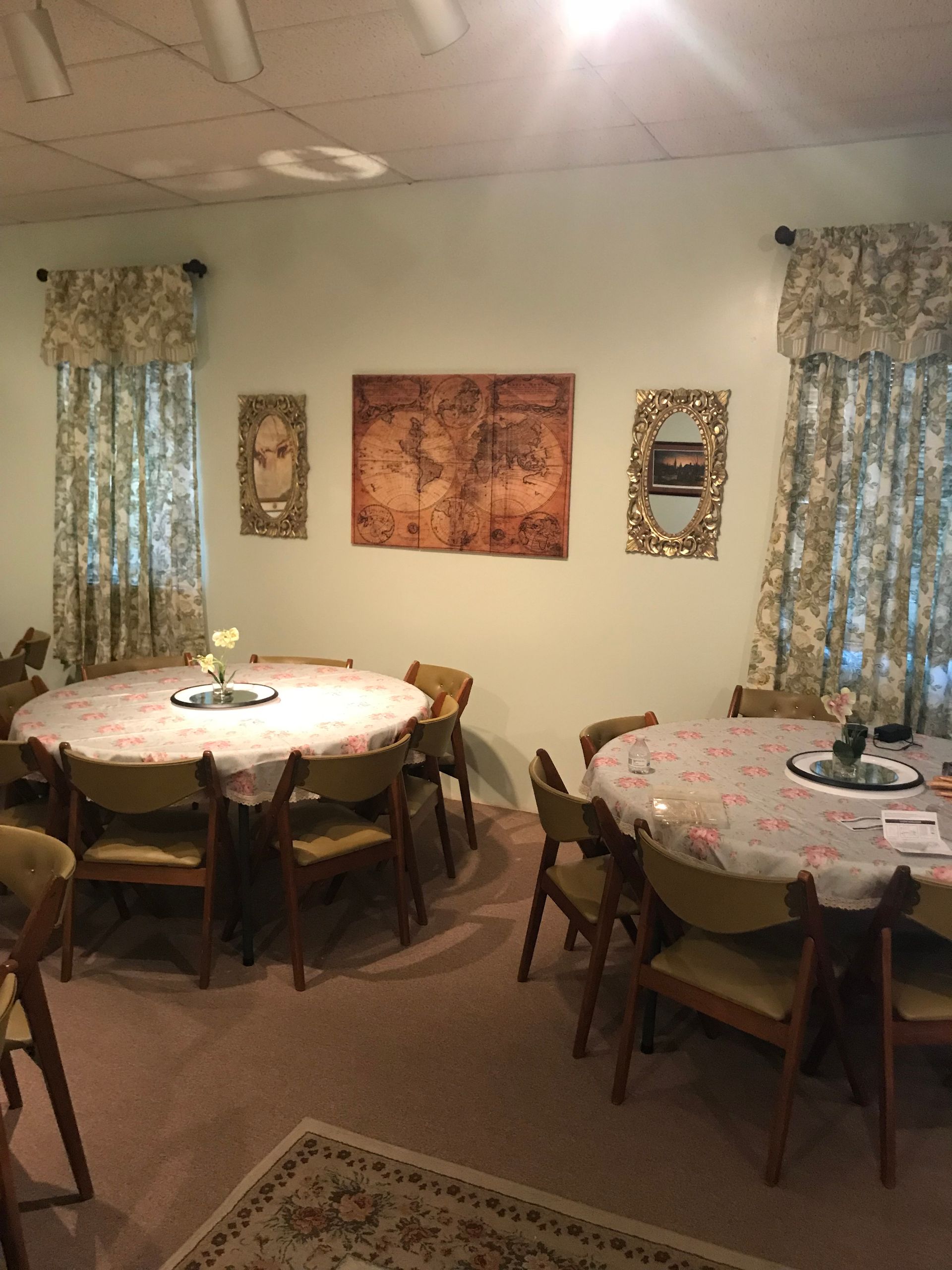 A room with tables and chairs and a map on the wall.