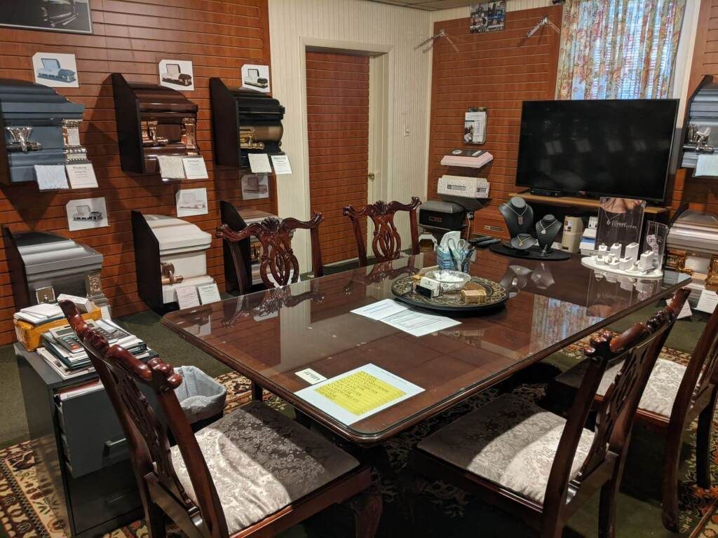 a conference room with a table and chairs and a flat screen tv .